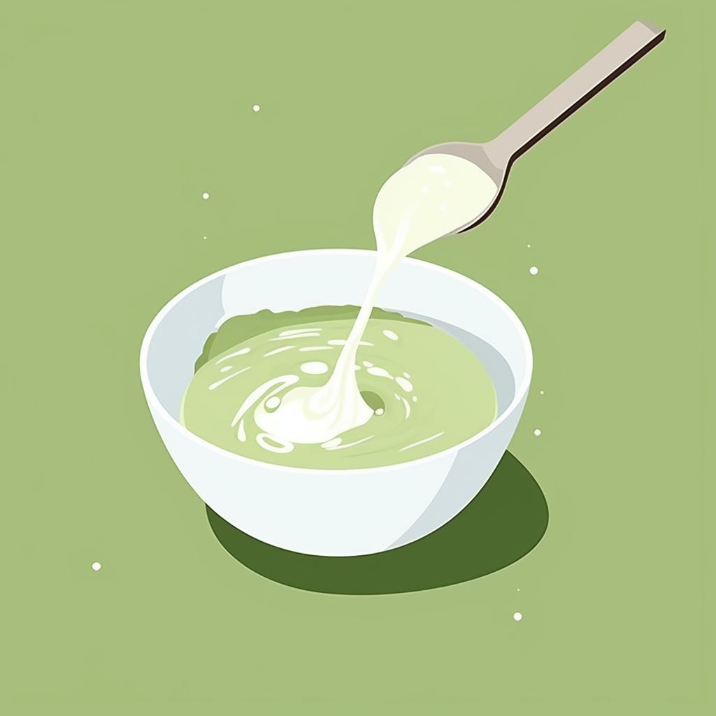 Milk being poured into a bowl of matcha paste