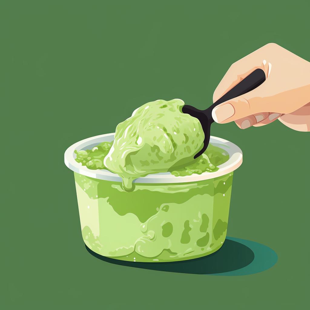Homemade matcha ice cream being scooped from a container.