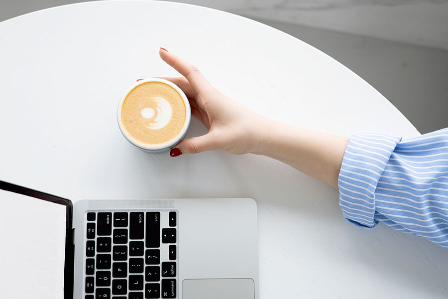 Cozy setting with a cup of matcha milk tea on a wooden table, surrounded by a warm blanket and a good book